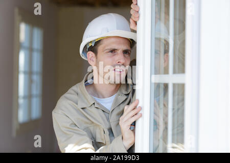 Die Teamarbeit zwischen Handwerker und Handwerker installieren Fenster Stockfoto