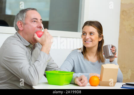 Frau und Mann essen Mittagessen in Design Studio Stockfoto