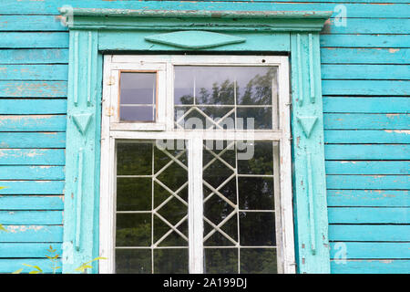 Alte Holz- Fenster mit Gittern in einer verlassenen Holzhaus Stockfoto