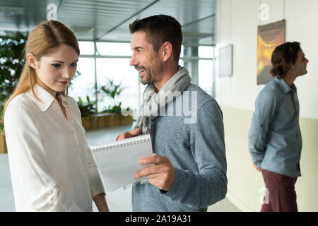 Man Notepad angezeigt, jungen Frau in eine Kunstgalerie Stockfoto