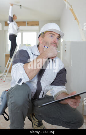 Bauarbeiter Notizen über die Zwischenablage in ein neues Haus Stockfoto