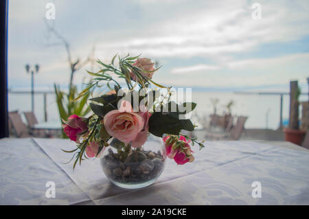 Blumenstrauß aus bunten Blumen in einer Glasvase auf einen Tisch in einem Restaurant. Stockfoto