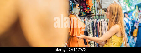 Frau Reisenden wählen Sie Souvenirs in den Markt in Ubud auf Bali, Indonesien BANNER, LANGE FORMAT Stockfoto