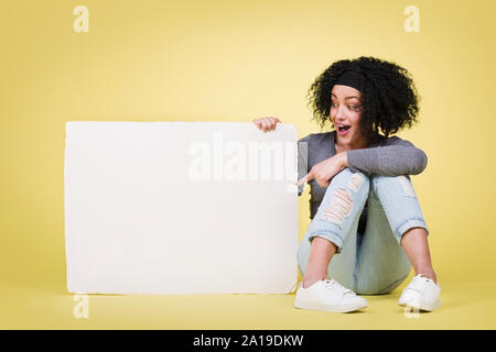 Aufgeregt Frau zeigt ein weißes Papier. Stockfoto