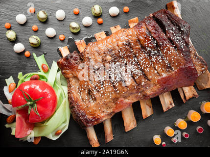 Saftig gebratene Rippen mit frischen Tomaten Stockfoto