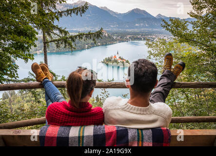 Junge Paar genießt die Aussicht auf den Bleder See aus dem Hügel Stockfoto