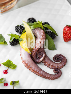 Octopus mit Beeren auf der Platine Stockfoto