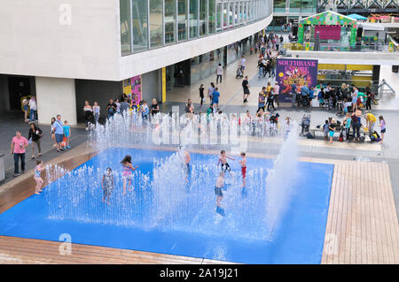 Kinder Spaß im Wasser spielen jet Brunnen in dem erscheinenden Zimmer Installation des Dänischen Künstlers Jeppe Hein, Southbank Centre, London, UK Stockfoto