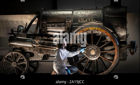 Führen Konservator Wendy Somerville-Woodiwis stellt Stephensons Rocket in seinem neuen Zuhause, das National Railway Museum in York, wo es auf Anzeige bis April nächsten Jahres sein wird. Stockfoto