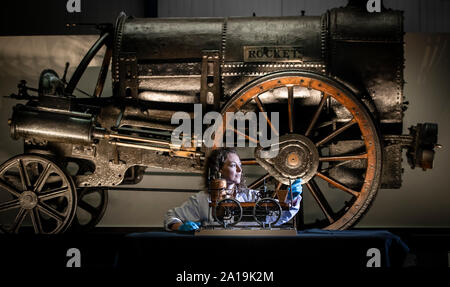 Führen Konservator Wendy Somerville-Woodiwis mit Stephensons Rocket und ein Modell Lokomotive, wie sie präsentiert neuen Start der Rakete, das National Railway Museum in York, wo es auf Anzeige bis April nächsten Jahres sein wird. Stockfoto