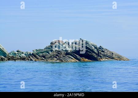 In der Nähe von grün-braunen Felsen im Meer Stockfoto