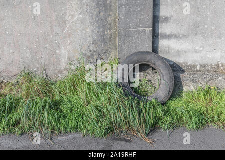 Altes Auto Reifen gegen eine Betonwand. Metapher fliegen - Trinkgeld, Umweltverschmutzung. Michelin Marke oben links Reifen daher ED nur. Stockfoto