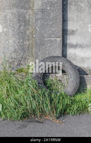 Altes Auto Reifen gegen eine Betonwand. Metapher fliegen - Trinkgeld, Umweltverschmutzung. Michelin Marke oben links Reifen daher ED nur. Stockfoto