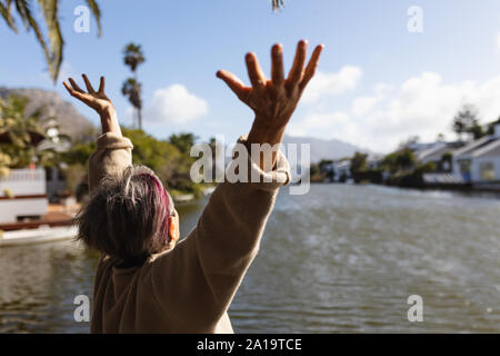 Ältere Frau, die ihre freie Zeit genießen, an einem See Stockfoto