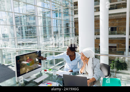 Weibliche Führungskräfte diskutieren über Computer am Schreibtisch Stockfoto