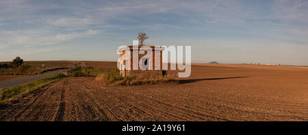 Alte Strom Umspannwerk auf das leere Feld ruinieren. Das Feld nach der Ernte im sonnigen Tag. Tschechische Republik Stockfoto