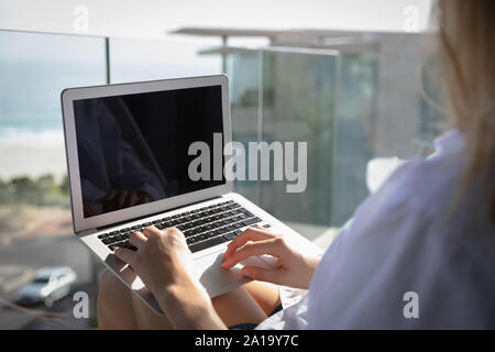 Junge blonde Frau mit Laptop Stockfoto