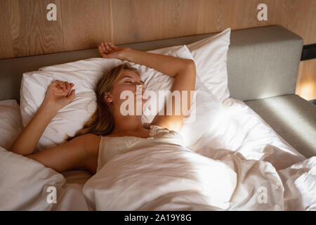 Junge blonde Frau im Bett schlafen Stockfoto