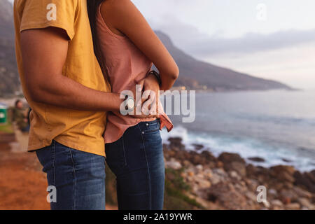 Junge Mixed Race Paar stehend auf einem Strand Stockfoto