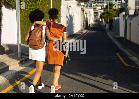 Zwei Frauen umarmen und Walking Stockfoto