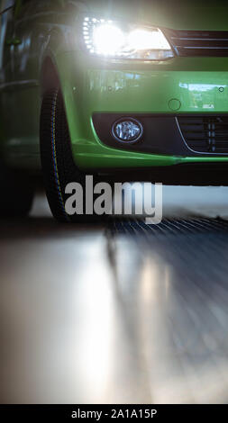 Auto in einer Garage für Wartung, Öl-/Reifenwechsel (flacher DOF; Farbe getonte Bild) Stockfoto