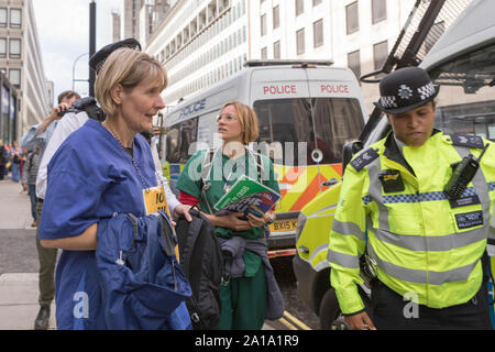 London, Großbritannien. 25 Sep, 2019. Ärzte aus der NHS die Umweltkampagne Gruppe Aussterben Rebellion, Sekundenkleber, sich dem Eingang außerhalb des Ministerium für Wirtschaft, Energie und industrielle Strategie, Victoria Street, Westminster. Credit: Penelope Barritt/Alamy leben Nachrichten Stockfoto