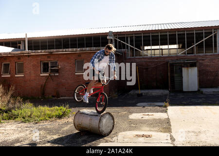 BMX rider tun Trick in einem leeren Hof Stockfoto