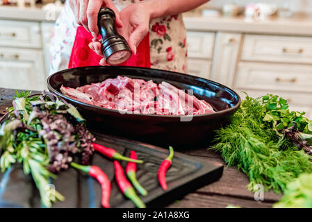 Nahaufnahme, Hände von Kochen salzen raw Hammel Rippen auf Pfanne Stockfoto