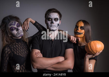 Mädchen und ein Kerl mit unheimlichen bemalten Gesichtern Skelette und Geister zu einer Halloween Party Stockfoto