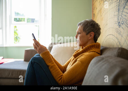 Reife Frau alleine zu Hause Stockfoto