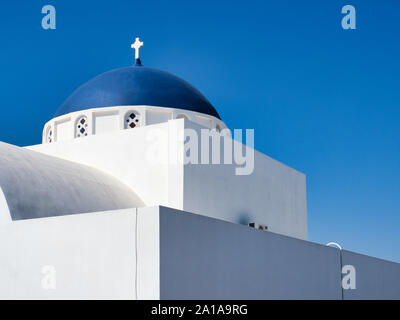 Von unten Gebäude und Glockenturm von Nikolaus Kloster in Santorini Griechenland unter blauem Himmel an einem sonnigen Tag Stockfoto