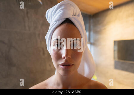 Portrait der Junge brünette Frau in ein Bad mit ihr das Haar in ein Handtuch gewickelt Stockfoto
