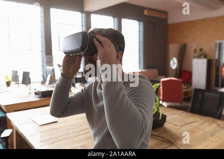 Junge kreative Professionelle man mit VR-Headset in einem sonnendurchfluteten Büro Stockfoto