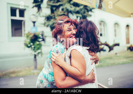 Nahaufnahme von zwei emotionale gerne ältere weibliche Freunde umarmen einander im Freien Stockfoto