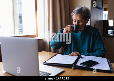 Ältere Frau Kaffee zu Hause trinken Stockfoto