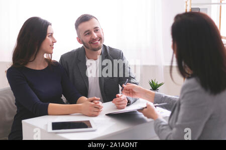 Junge Familie hören, Finanzberater, bereit, Kredit Vertrag zu unterzeichnen Stockfoto