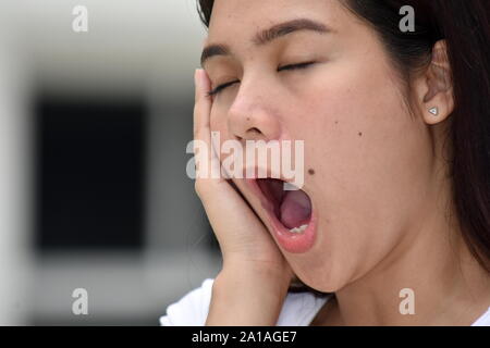 Eine attraktive Diverse Frau Gähnen Stockfoto