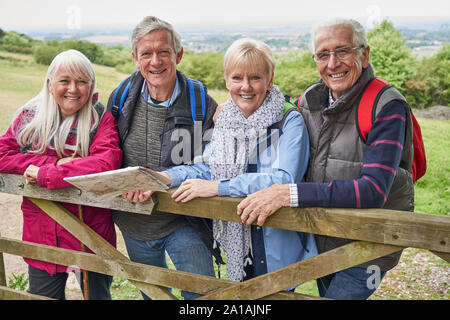 Porträt der Gruppe von älteren Freunden Wandern in der Landschaft stehend von Gate Stockfoto