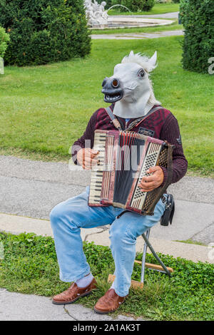 Mann mit dem Pferd kopfschmuck Klavier Akkordeon vor dem Kunsthistorischen Museum, Wien, Österreich. Stockfoto