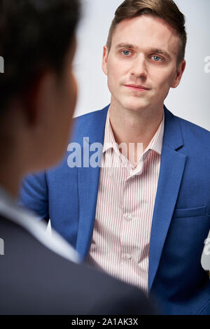 Studio Shot der Geschäftsmann interviewen Geschäftsfrau für Beschäftigung vor weißem Hintergrund Stockfoto