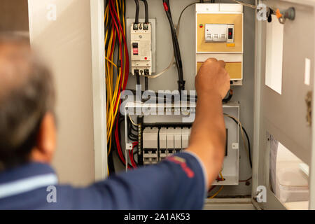 Elektromeister Messung der Spannung in der Sicherungstafel. Stockfoto