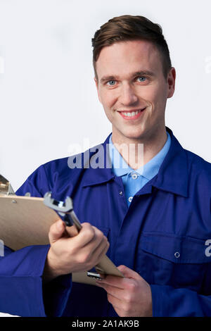 Studio Portrait von männlichen Ingenieur mit Zwischenablage und Schraubenschlüssel gegen den weißen Hintergrund Stockfoto
