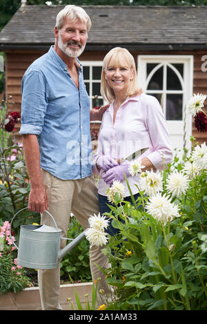 Portrait von Reifes Paar Arbeiten in Blumenbeete im Garten zu Hause Stockfoto