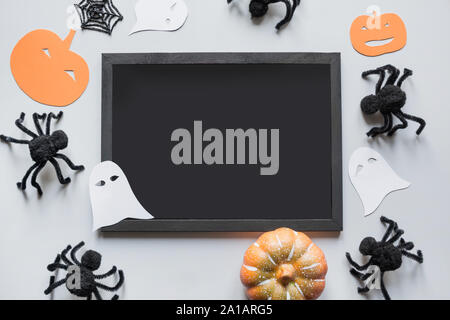 Halloween blank mit Platz für Text und Party Einrichtung, schwarze Spinnen, Kürbis, weiße Gespenst in Grau. Flach, Ansicht von oben, kopieren. Stockfoto