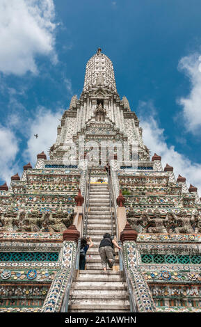 Besucher klettern die zentralen Prang (Turm) an der Wat Arun Tempel, auf dem Fluss Chao Phraya. Yai district, Bangkok, Thailand Stockfoto