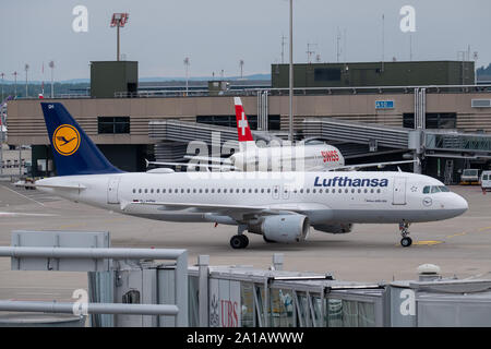 Zürich, Schweiz - 19. Juli 2018: Flughafen Zürich Gebäude Exterieur Landschaft am Tag Zeit, Lufthansa Flugzeug im Vordergrund Stockfoto