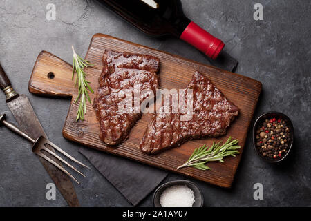 Gegrilltes Rindfleisch Steak auf Holzbrett und Rotwein. Ansicht von oben flach Stockfoto