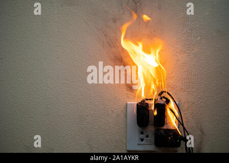 Auf Feuer Adapter an der Steckdose auf weißem Hintergrund, Elektrischer Kurzschluss Fehler in Strom Kabel resultierende verbrannt Stockfoto