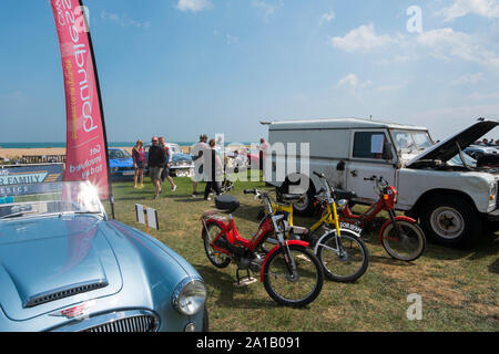 1970 s Puch und Tomos Mofas neben einem 50er Austin Healey 3000 Mkll und ein Land Rover das Angebot Classic Motor Show auf Walmer Grün durch den Strand, Dea Stockfoto