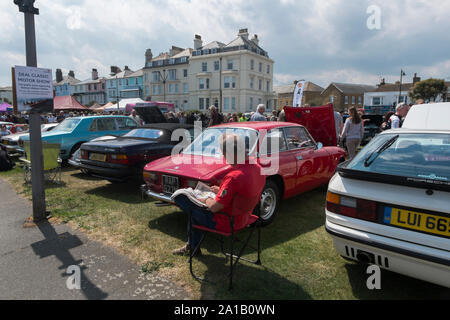 Eigentümer sitzt neben seinem roten 60er Alfa Romeo 2000 Sprint im Angebot Classic Motor Show auf Walmer Grün durch den Strand, Deal, Kent, Großbritannien Stockfoto